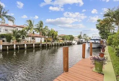Private boat dock along a canal in Caribbean Keys Boca Raton with tropical landscaping and waterfront homes.